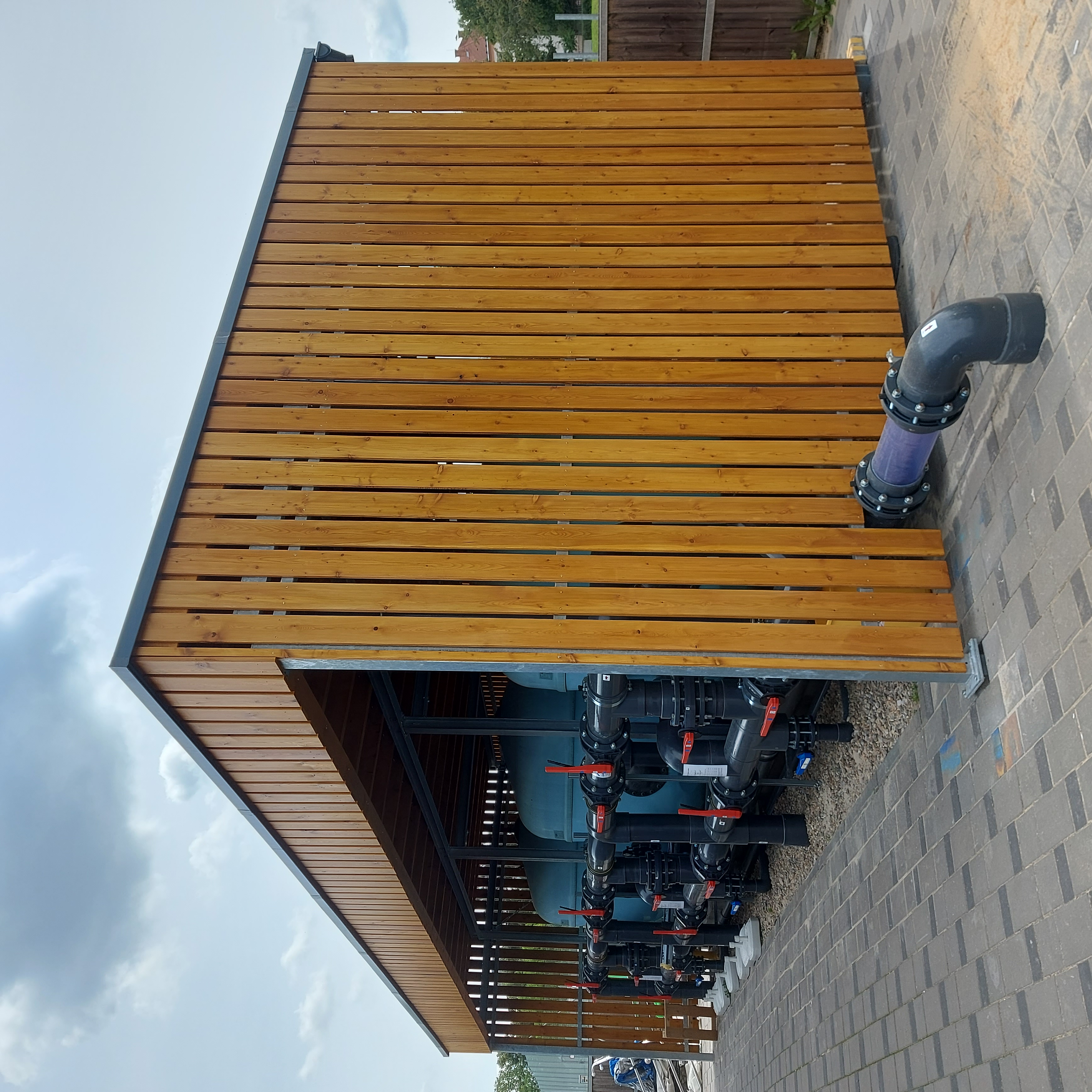 Dřevěný přístřešek s lamelami pro technické zázemí