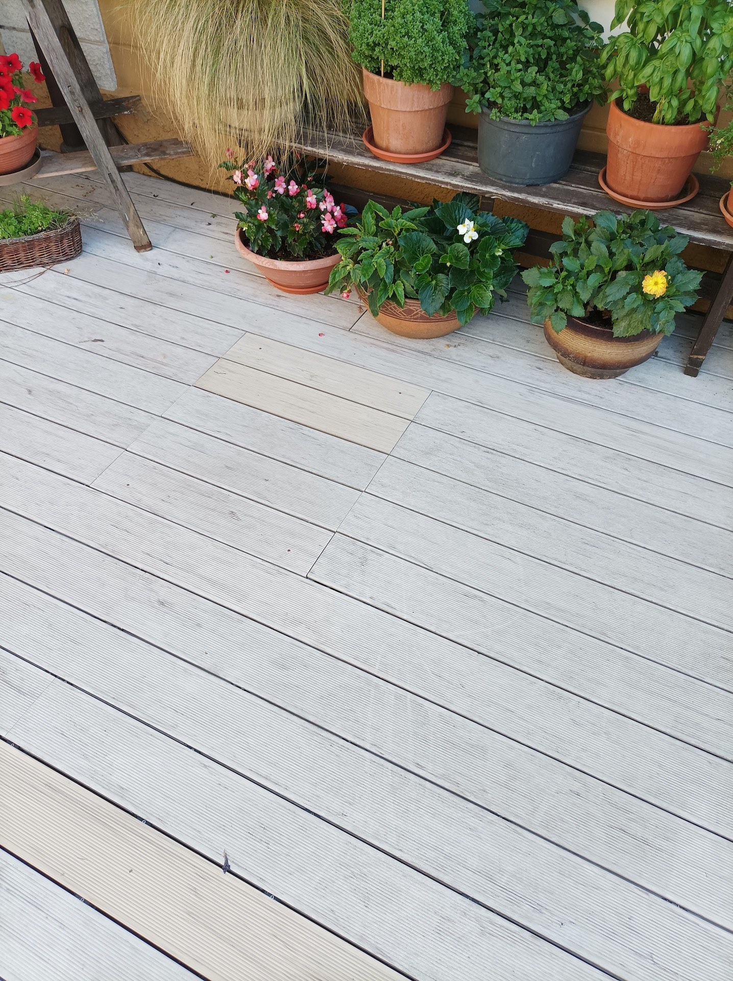 Šedá kompozitní terasa s květinovou výzdobou