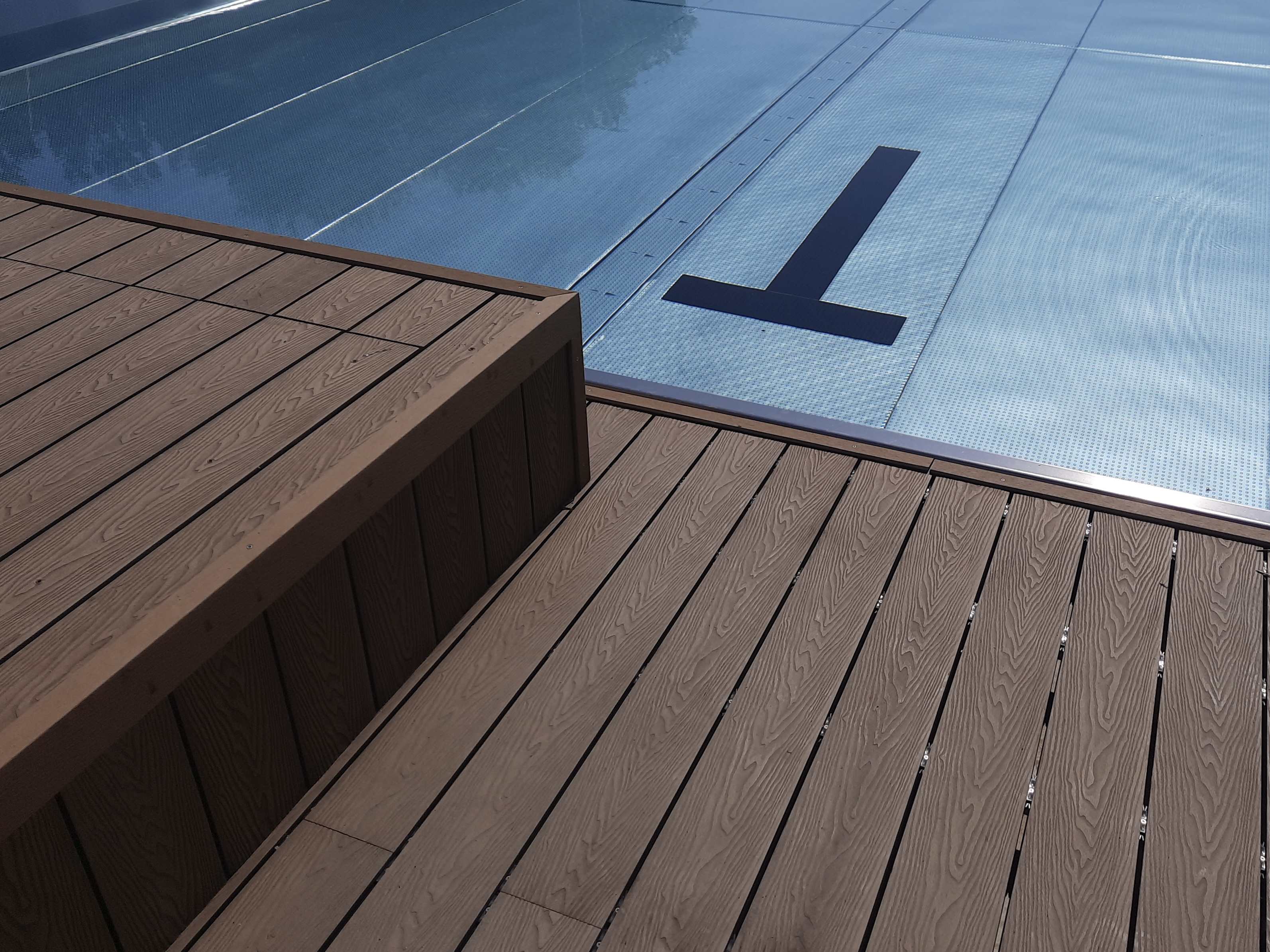 Tmavá WPC terasa u bazénu s krytem