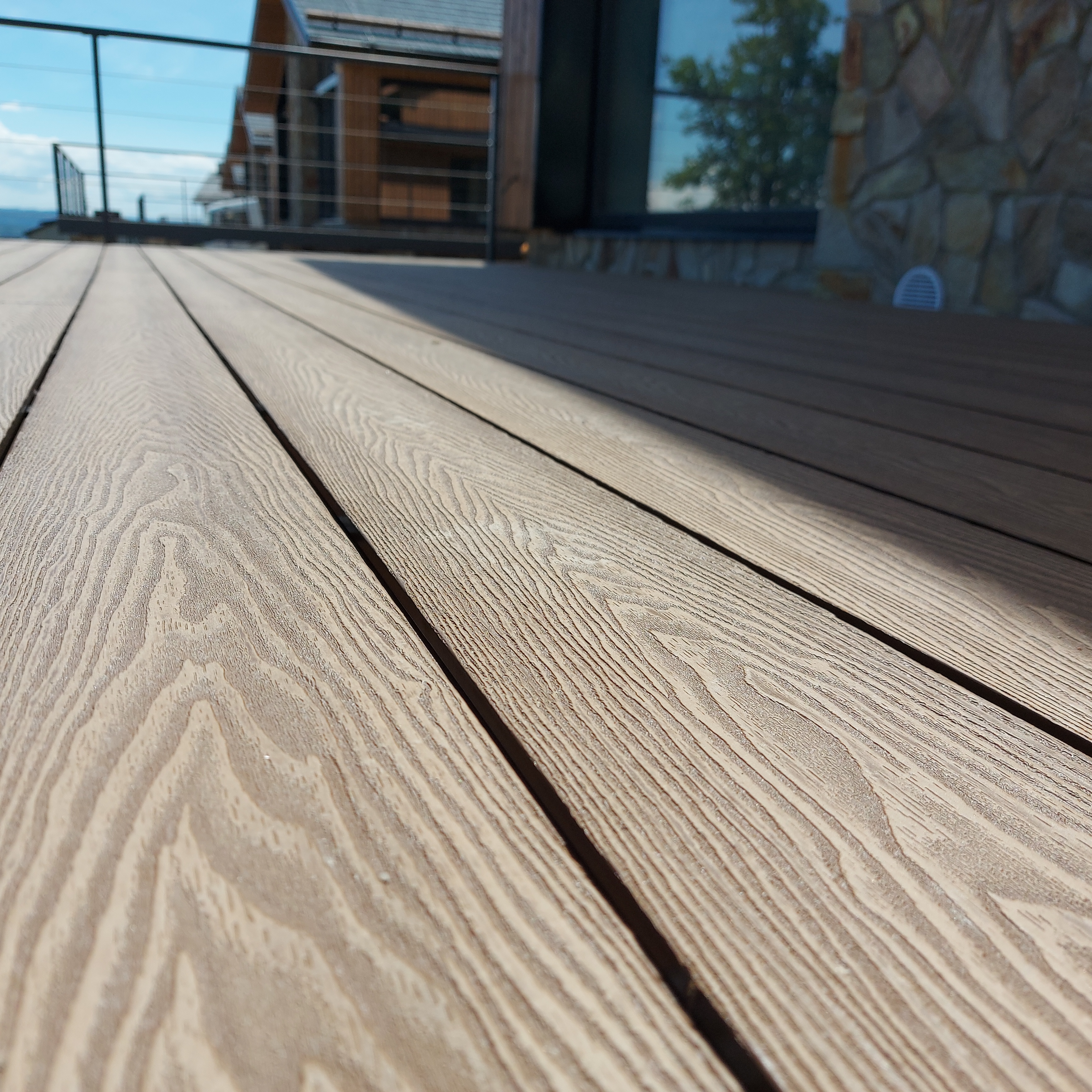 Detail WPC prken u domu s kamennou fasádou