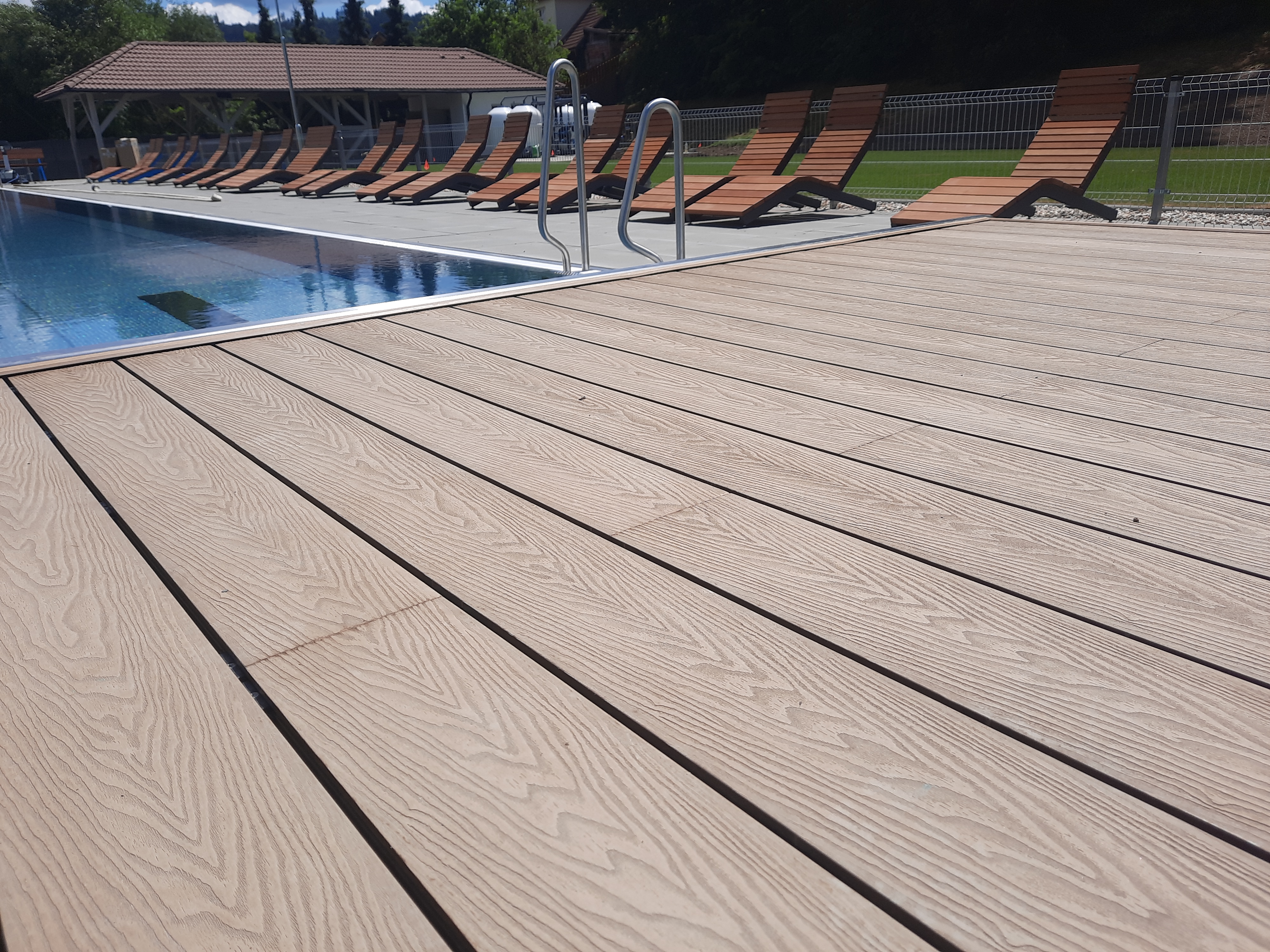 WPC terasa u veřejného koupaliště s lehátky